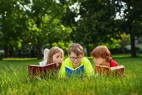 Kids reading in grass